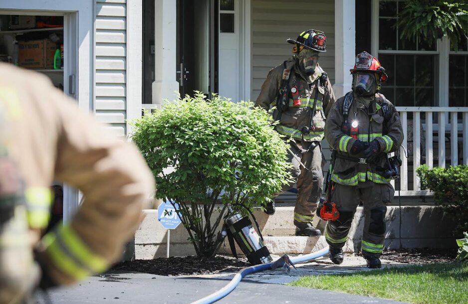 Huntley firefighters walkng out of house